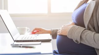 pregnant woman is working on computer laptop and mobile phone, business